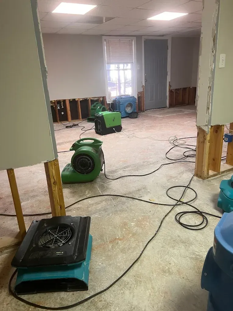 Restoration specialist cleaning smoke-damaged walls inside a home after a small fire